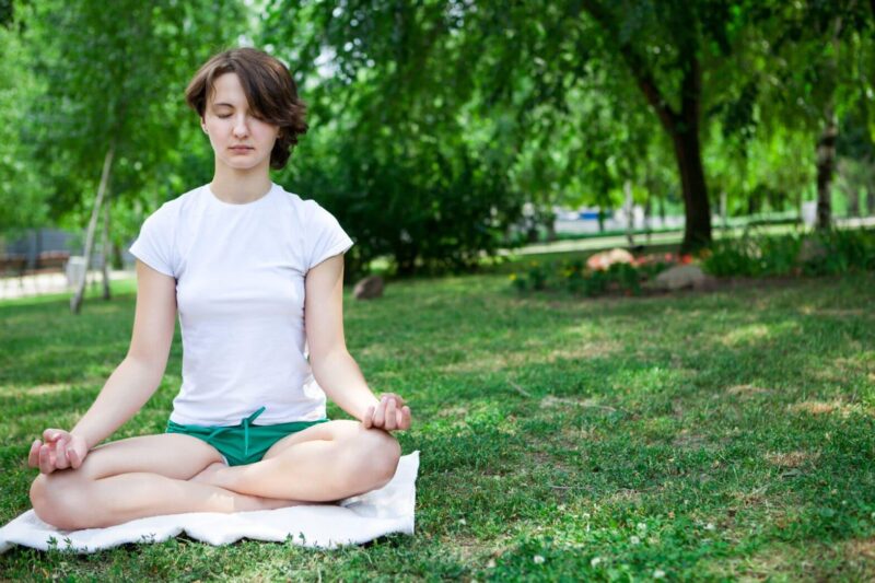 Meditation - Girl Meditating in Green Grass Park